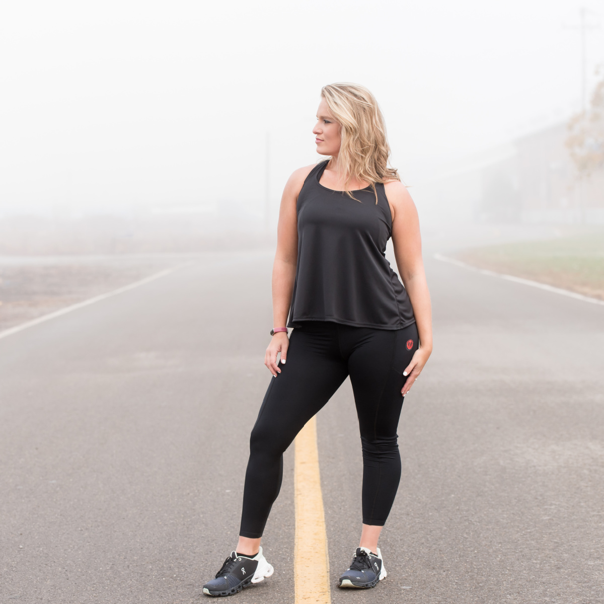 Woman wearing a black workout tank top and black leggings